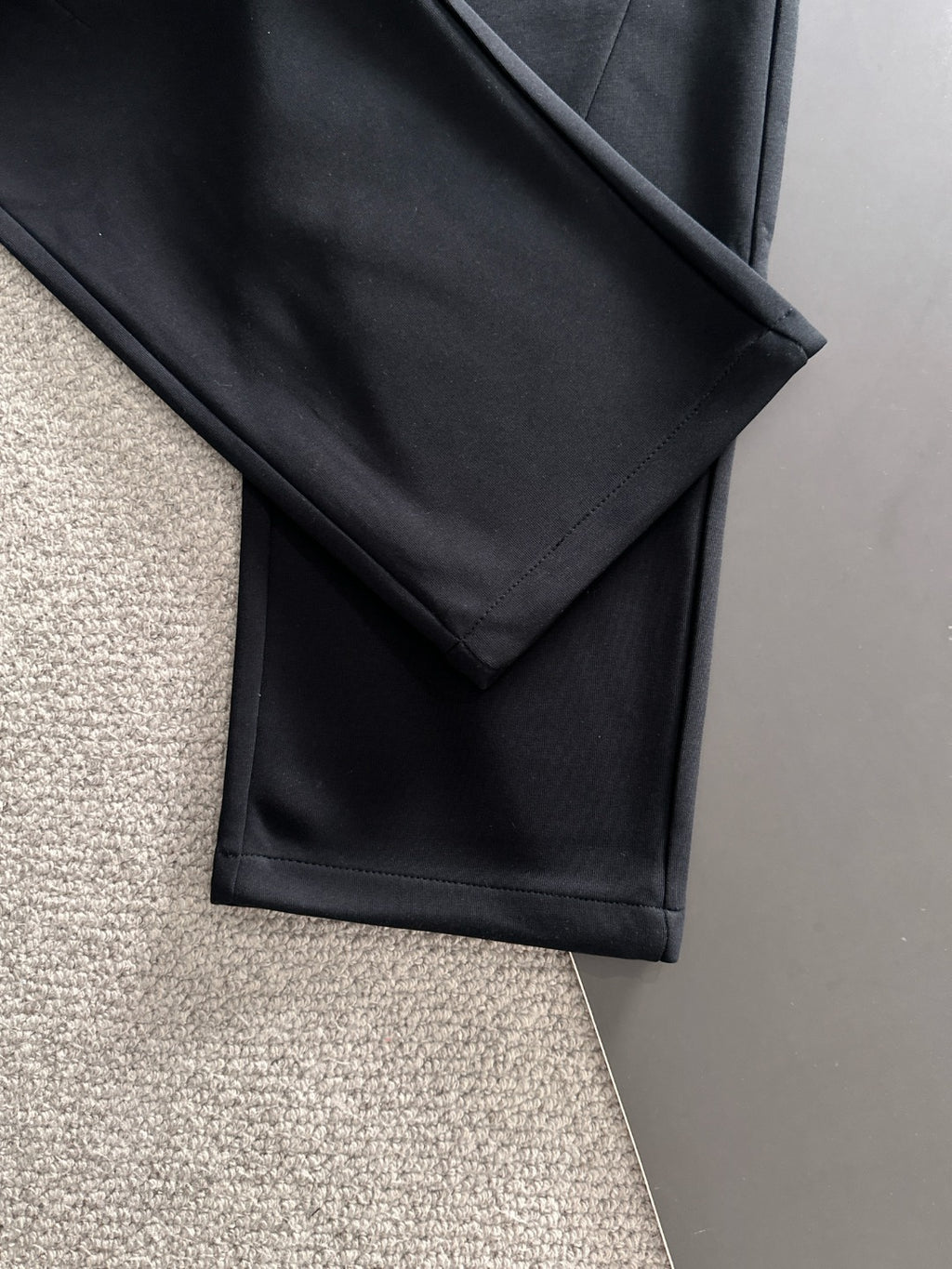 Black straight-leg pants with side seam and stitched fold