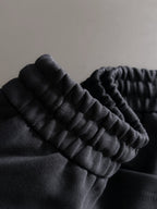 Black pants fabric close-up with ribbed elastic waistband detail