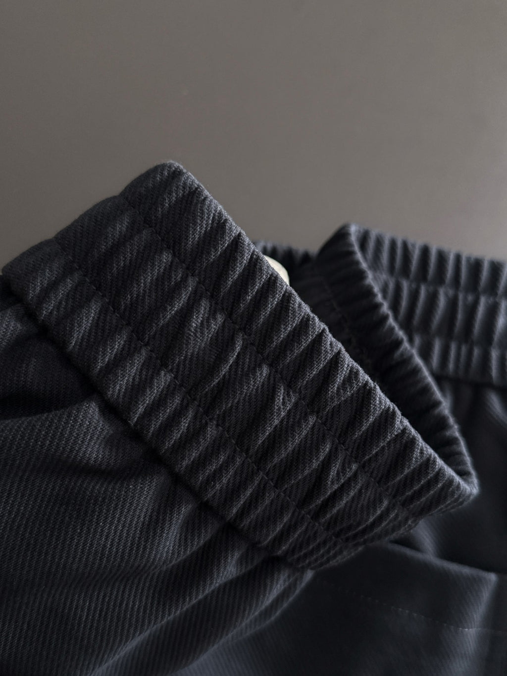 Navy pants fabric detail with textured weave and elastic waistband