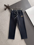 Navy drawstring pants with elastic waistband, front logo patch, cuffed straight legs