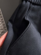 Navy pants close-up with stitched seam detail and elastic waistband