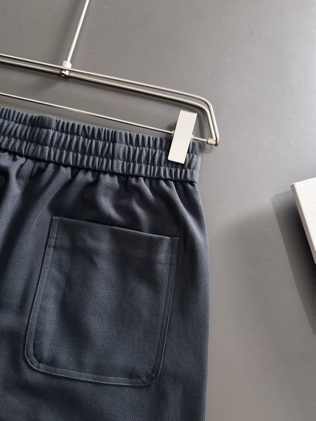 Navy pants with elastic waistband, front pocket, and drawstring ties