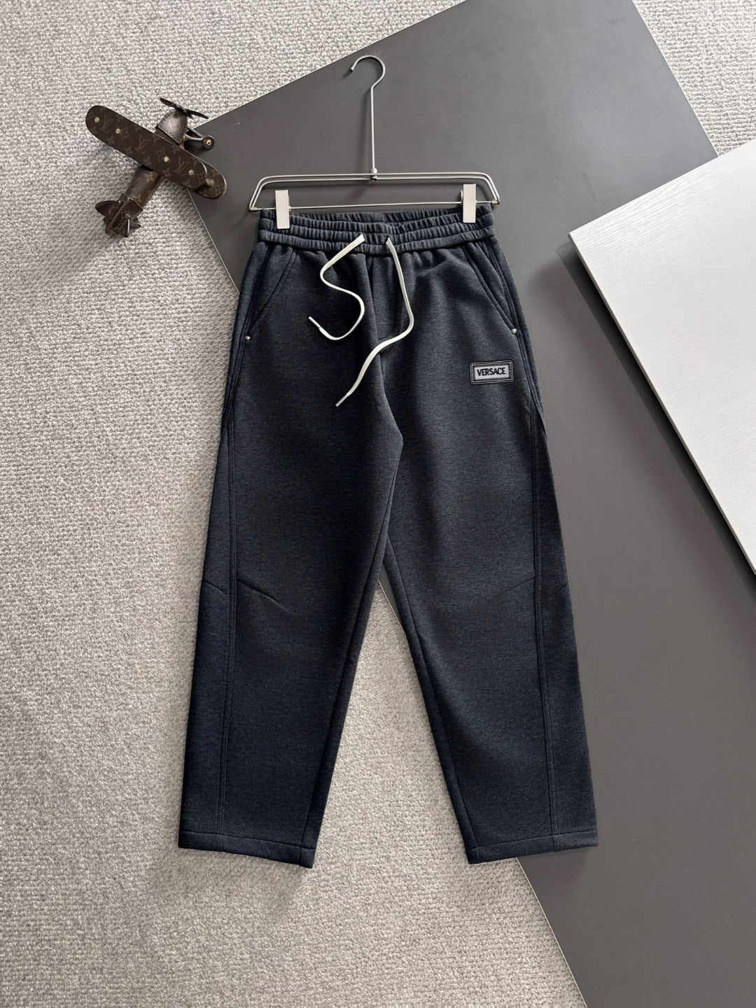 Dark navy jogger pants with elastic waistband, drawstring, and Versace logo patch