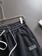 Dark jogger pants close-up of drawstring, elastic waistband, and Versace logo patch