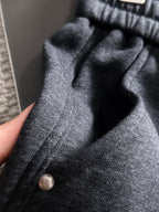 Dark jogger pants ribbed waistband, front button, and textured fabric