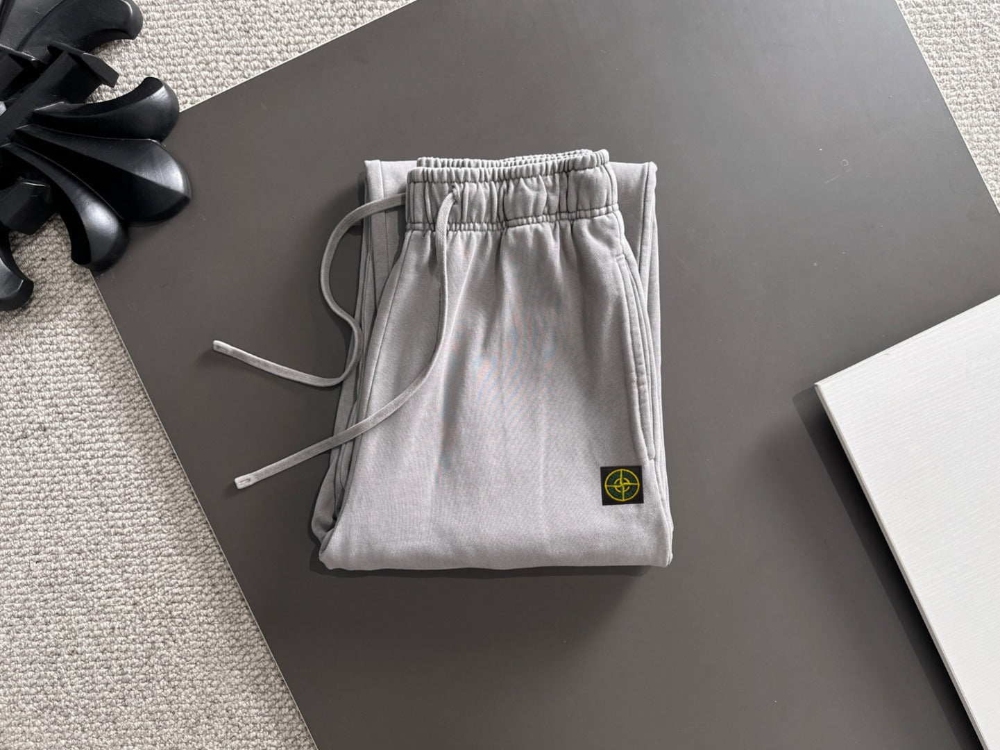 Stone Island light gray sweatpants with elastic waistband and hanging drawstring ties