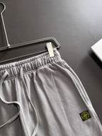 Stone Island light gray sweatpants with front pocket, elastic waistband, and drawstring