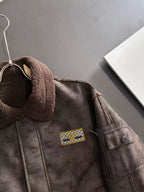 Brown shearling-collar jacket with gold-toned logo patch and side button flap