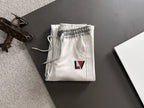 Louis Vuitton pants folded in white with elastic waistband and multicolor LV logo patch