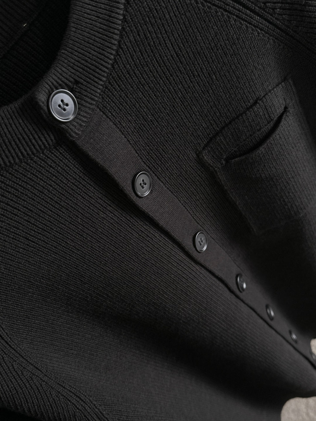 Black cardigan button placket and pocket detail