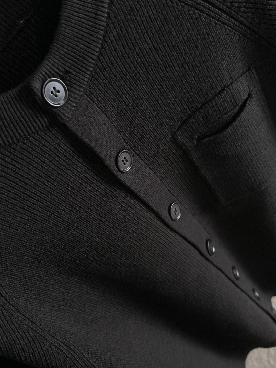 Black cardigan button placket and pocket detail