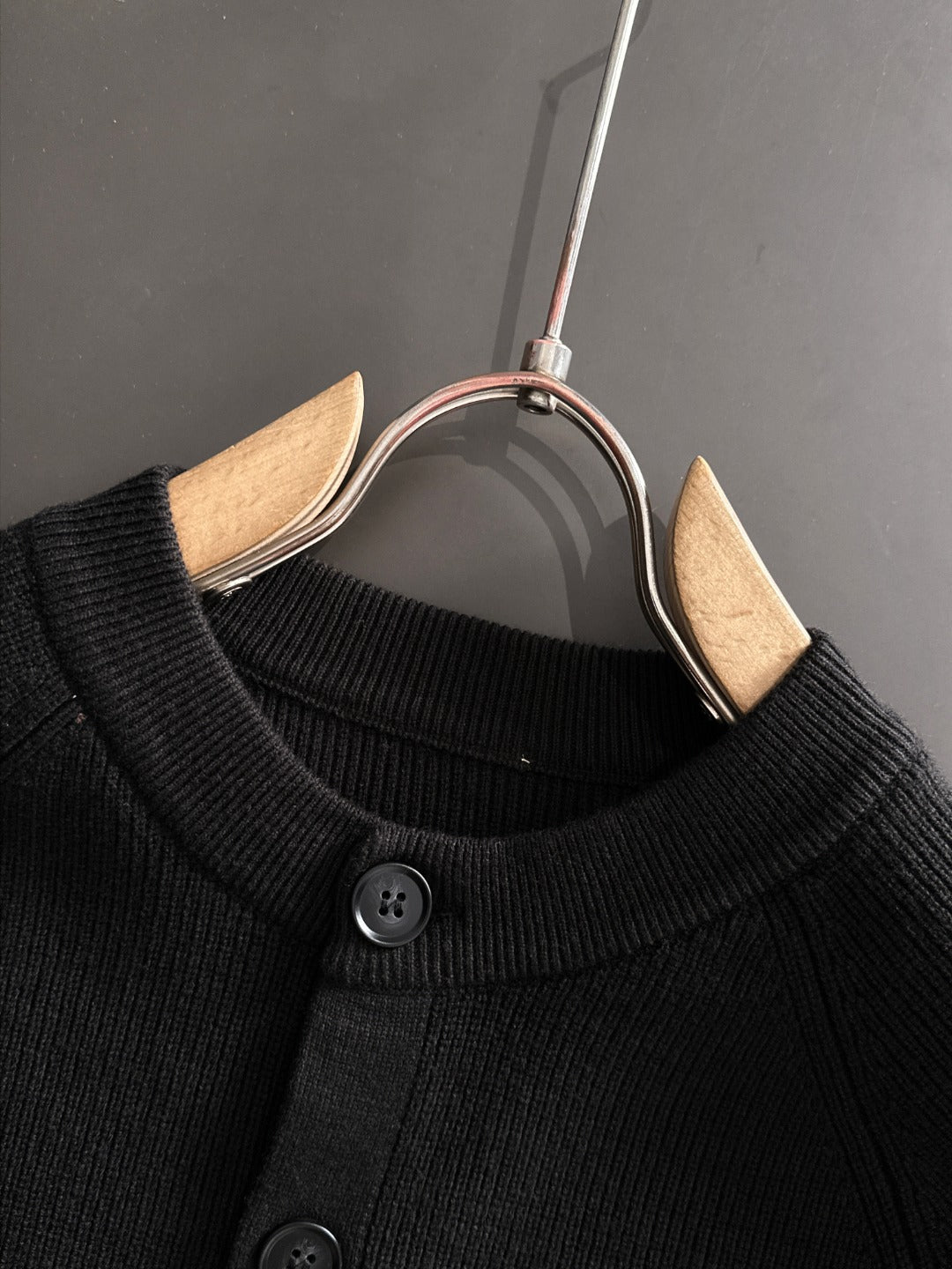 Black cardigan neckline with round button detail