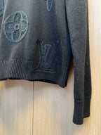 Dark knit sweater sleeve with ribbed cuff and embroidered detail