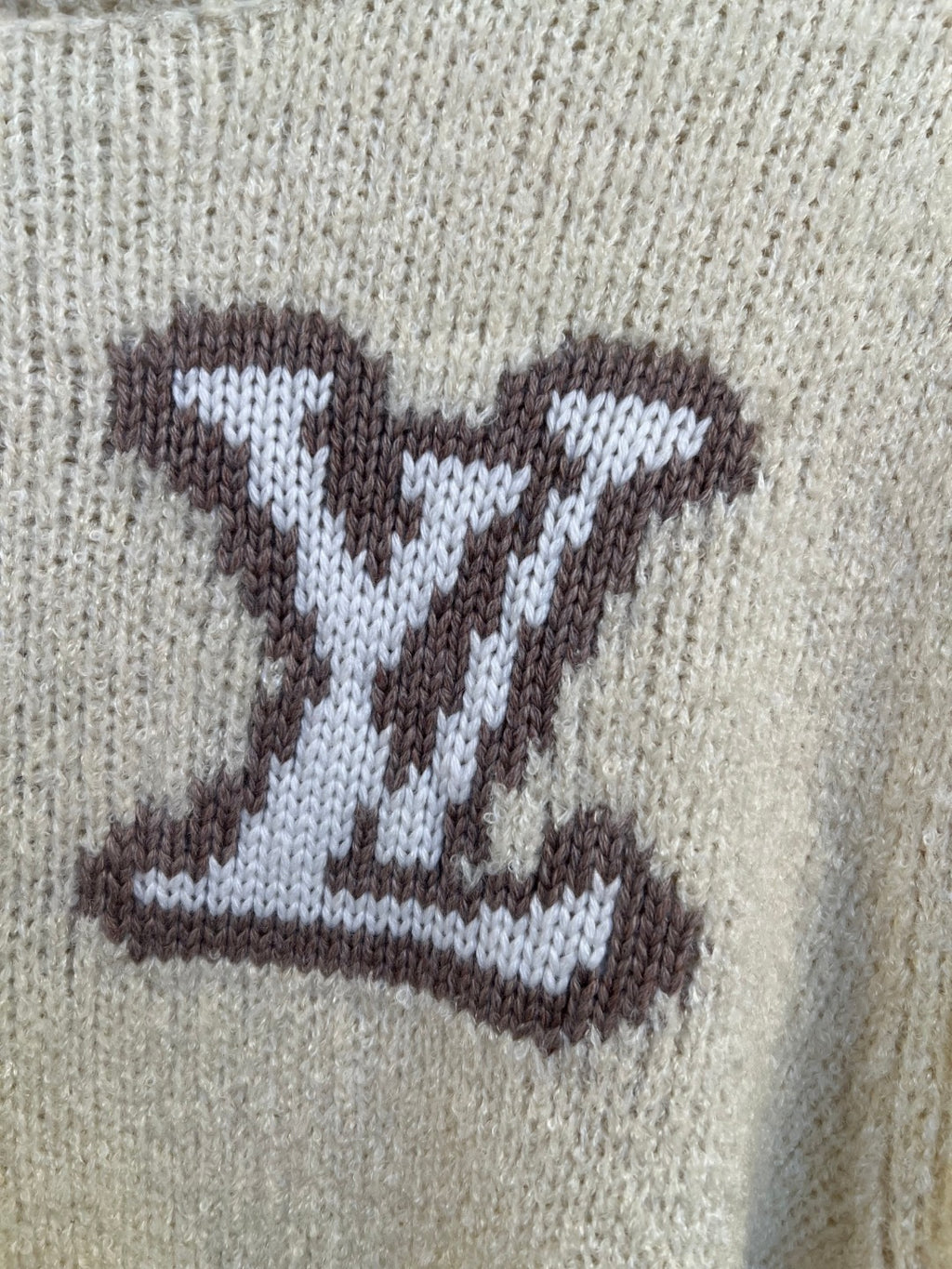 LV monogram intarsia on light cream knit sweater, close-up