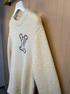 Light cream knit sweater with crew neck and dark LV monogram on front, side view