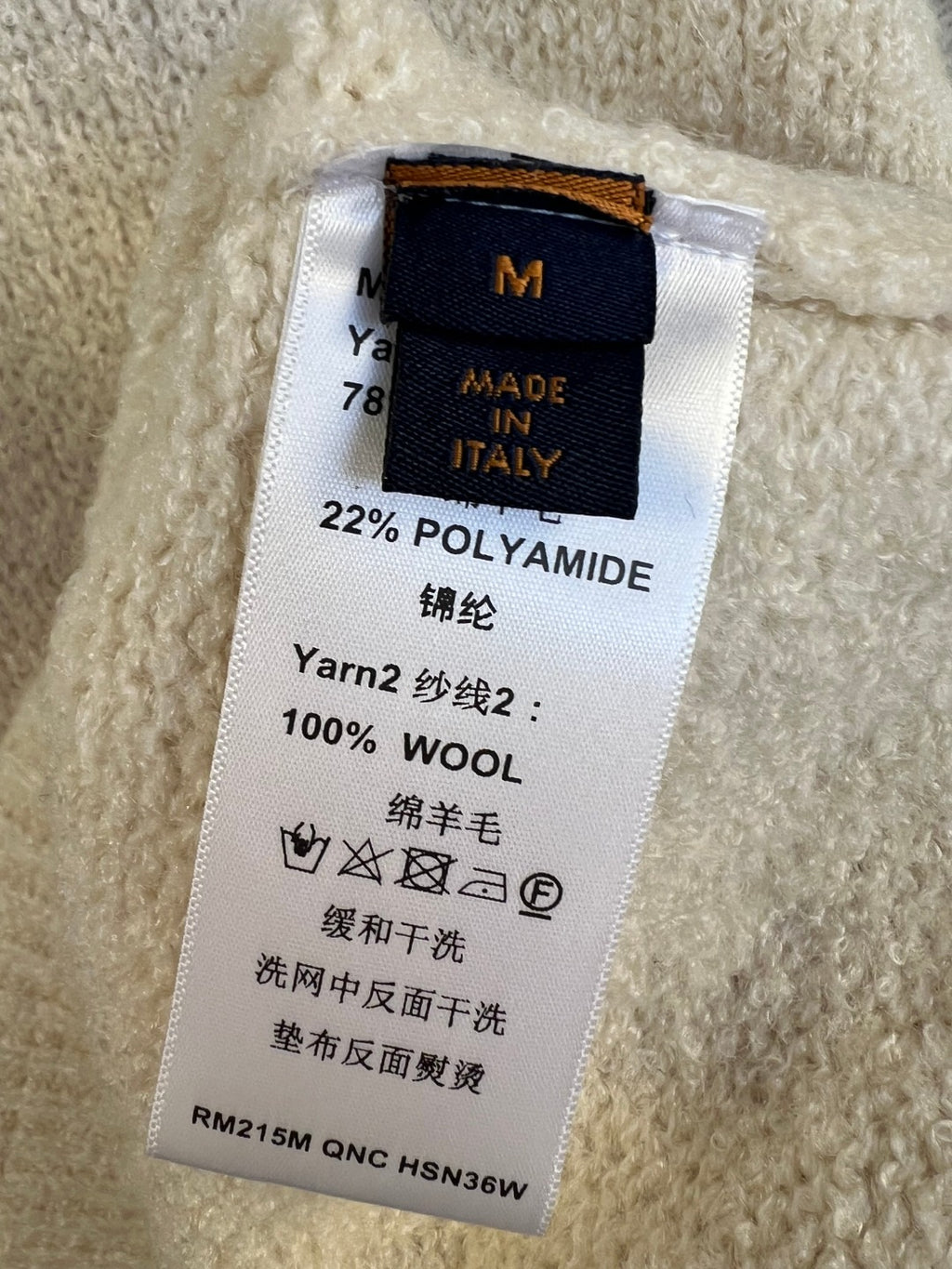 Inside neck label on knit sweater: 100% wool, made in Italy, size M