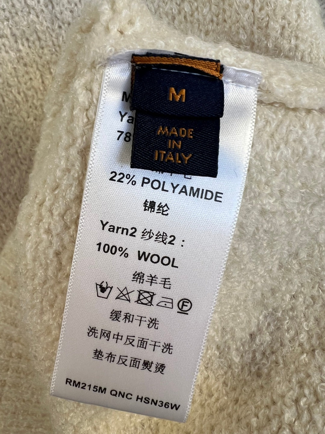 Inside neck label on knit sweater: 100% wool, made in Italy, size M