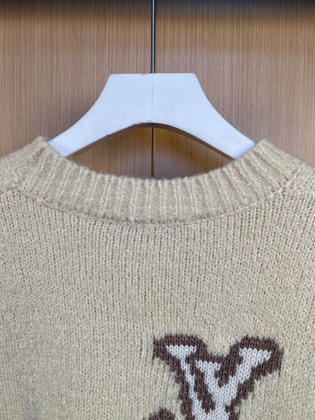 Light cream knit sweater neckline with ribbing and partial LV monogram, close-up