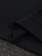 Close-up of black T-shirt hem with stitched edge and fabric texture