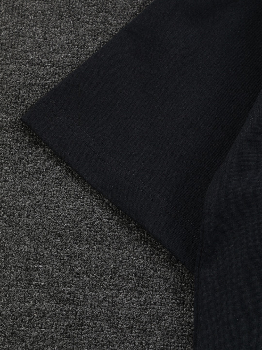 Folded black short-sleeve T-shirt with clean side seam