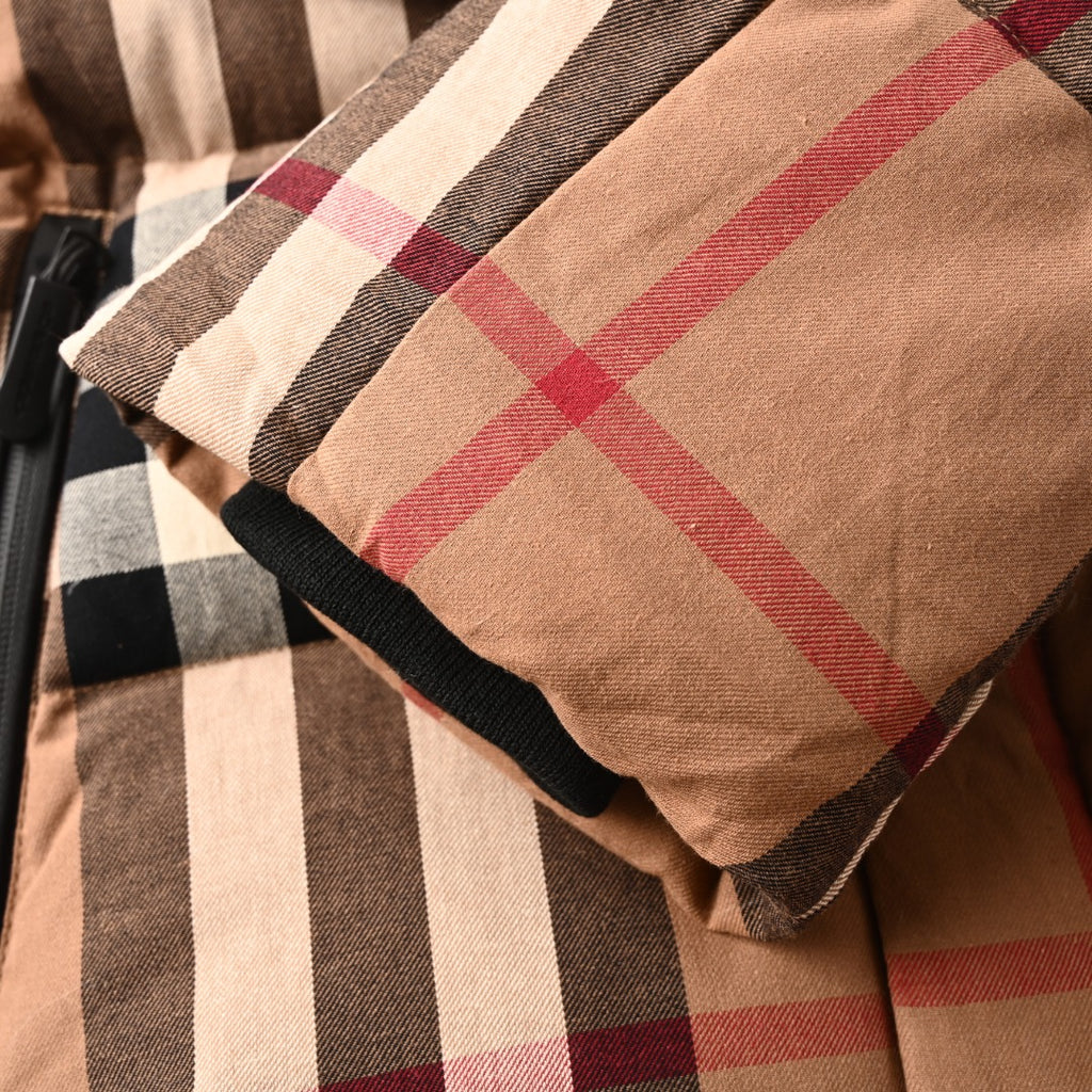 Plaid sleeve cuff with black elastic trim on long quilted jacket