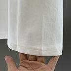 White long-sleeve T-shirt sleeve hem detail with visible stitching line