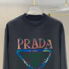 Prada long-sleeve top, dark navy, PRADA wordmark with colorful triangular graphic
