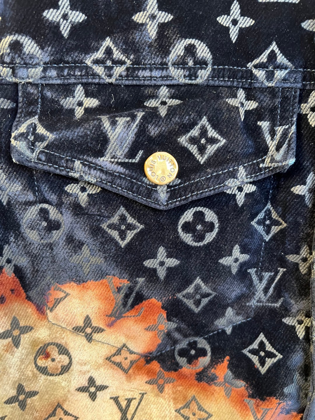 Louis Vuitton monogram jacket pocket with gold logo button and dark denim texture