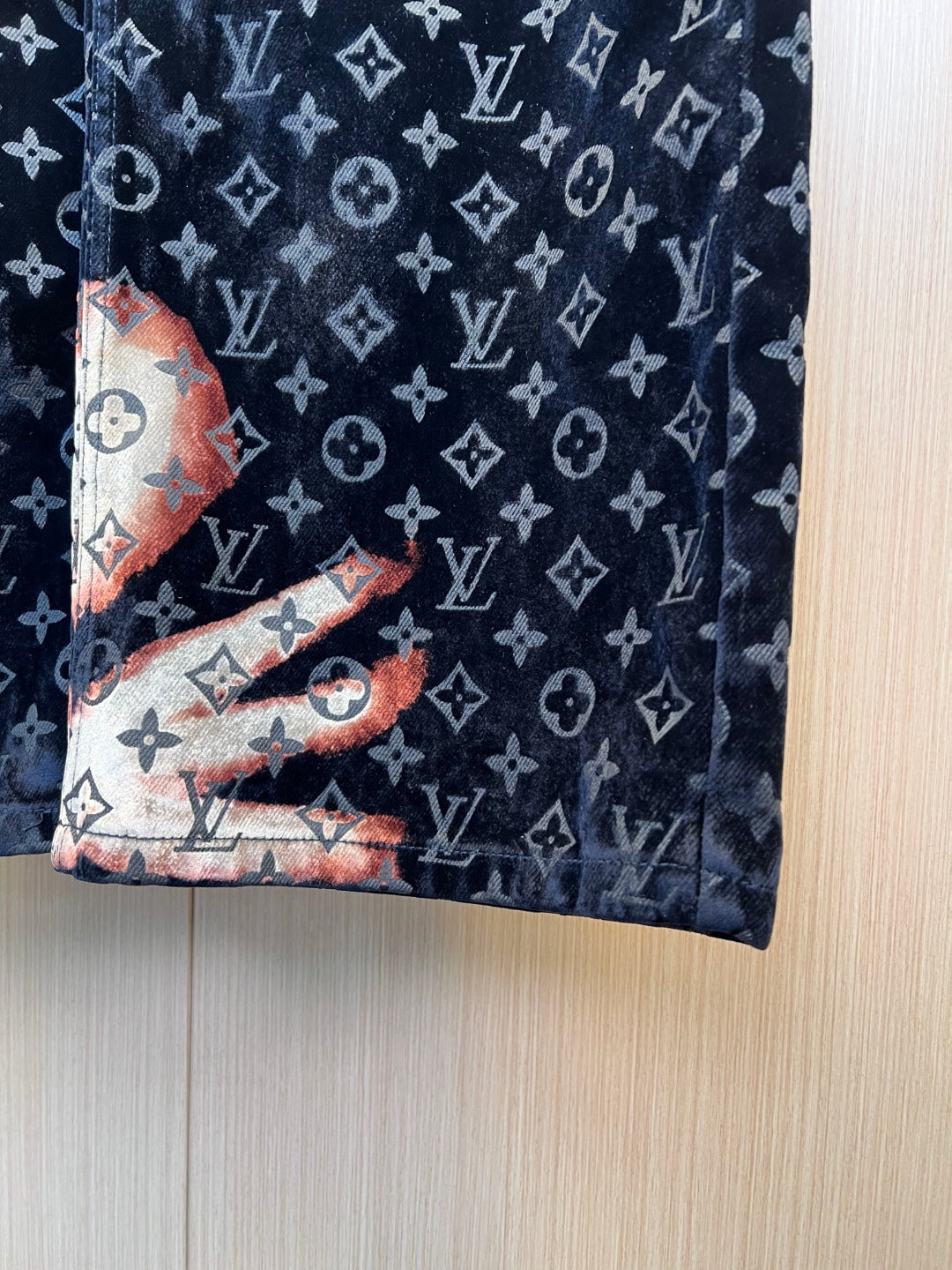 Louis Vuitton monogram pants fabric close-up in dark navy with orange accents