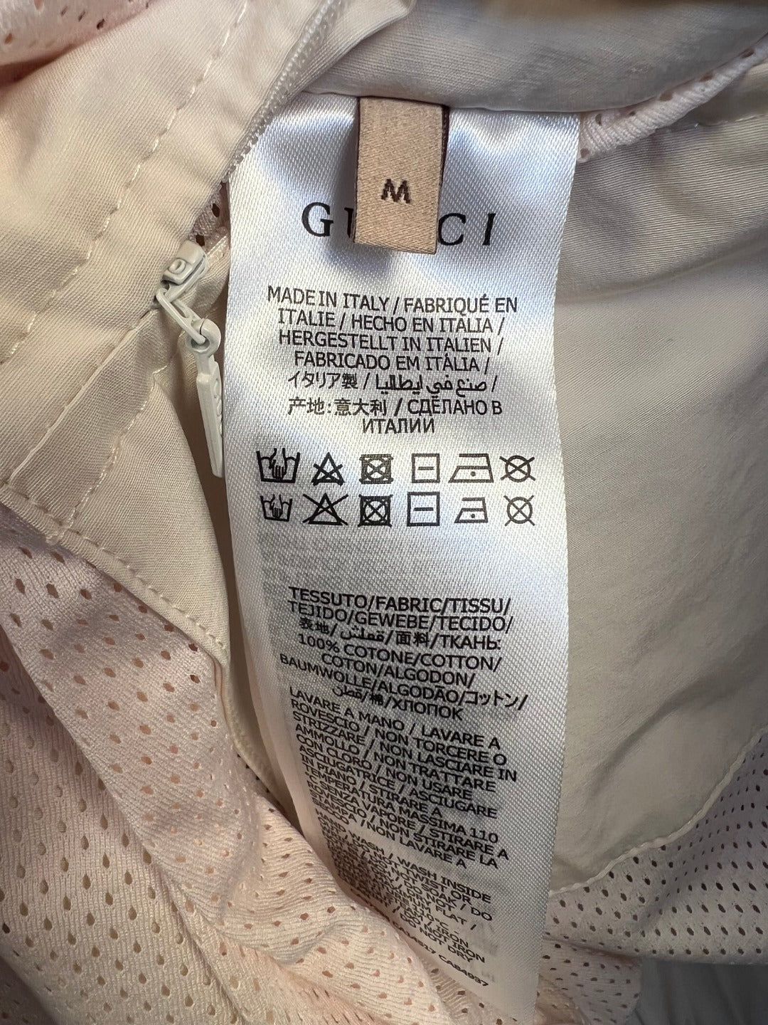 Inside garment care label with size tag and fabric composition text