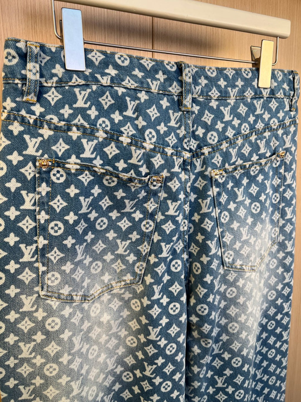 Blue monogram denim pants with front pockets and button closure