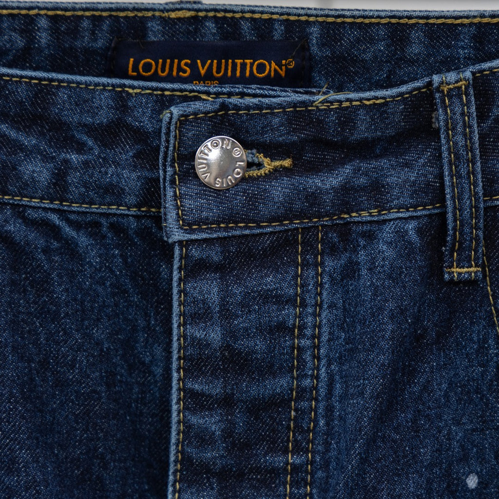 Waistband label of dark blue denim jeans with Louis Vuitton logo and metal button