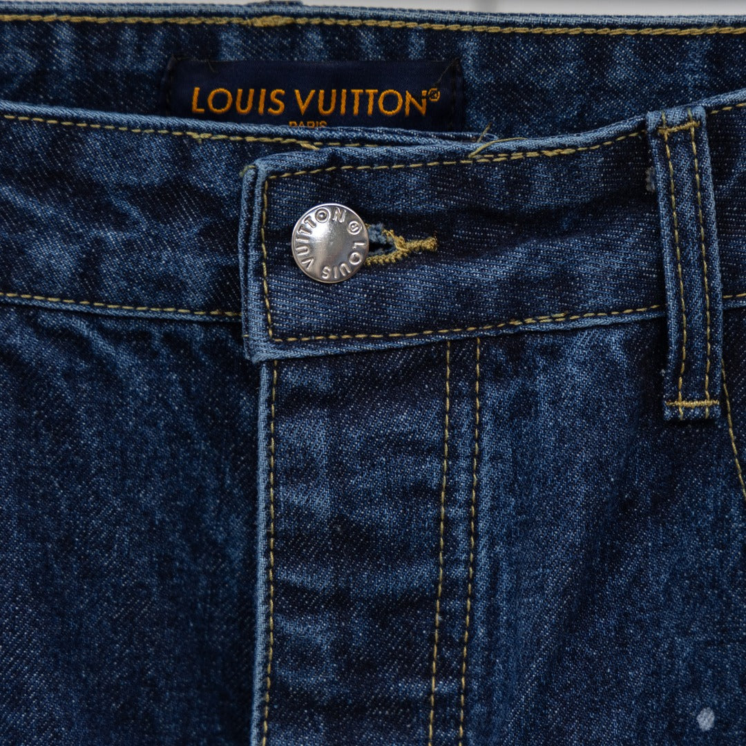 Waistband label of dark blue denim jeans with Louis Vuitton logo and metal button
