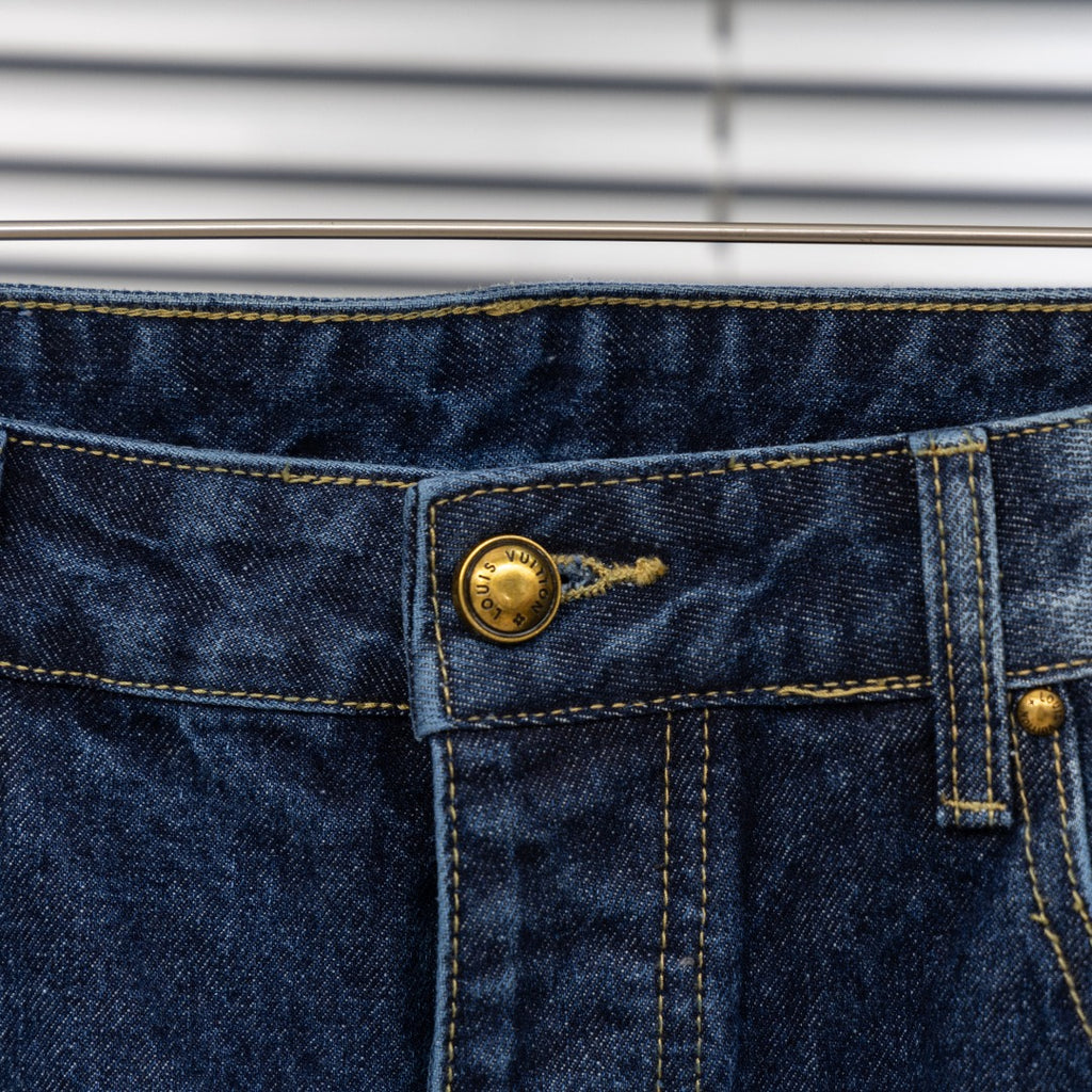 Denim pants waistband detail with gold button and stitched center seam