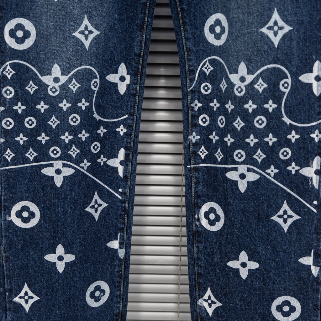 Denim pants leg close-up with white monogram pattern and contrast stitching
