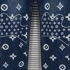 Denim pants leg close-up with white monogram pattern and contrast stitching