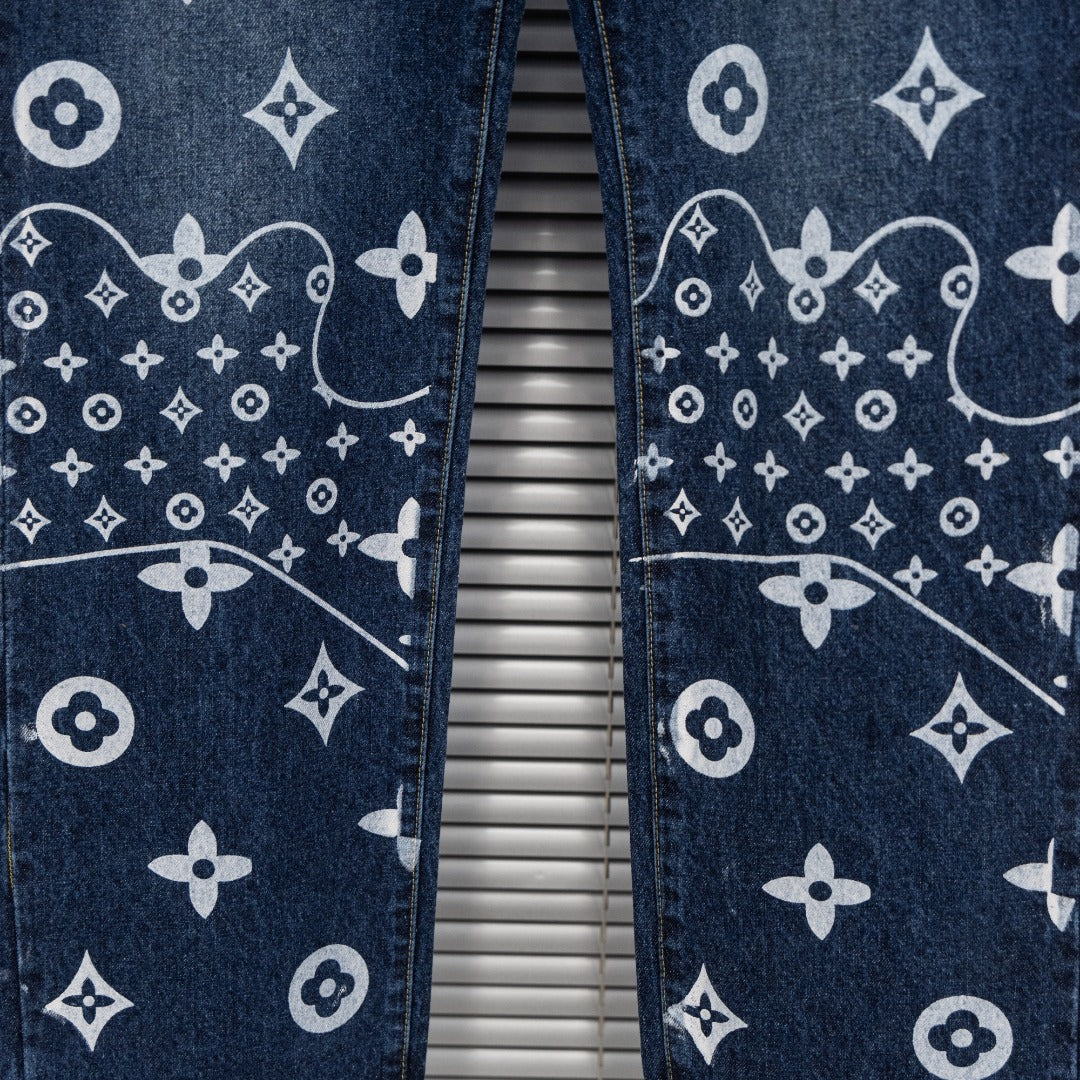Denim pants leg close-up with white monogram pattern and contrast stitching