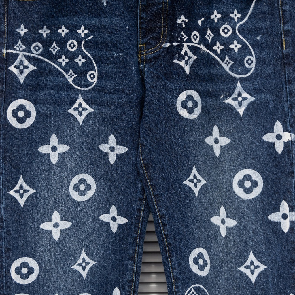 Denim pants close-up of leg print with white monogram motifs and curved lines