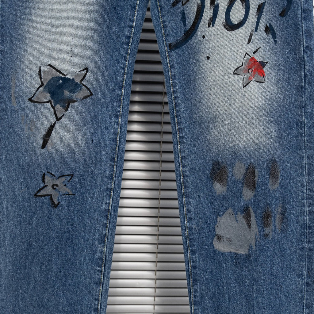 Dior denim pants side with star graphics and dark paint marks on leg
