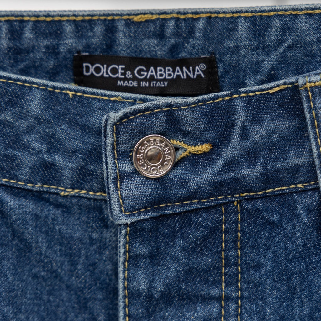 Dior denim pants waist button detail with Dolce & Gabbana tag and stitching