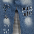 Dior denim pants close-up with star graphics and dark paint splatter on legs