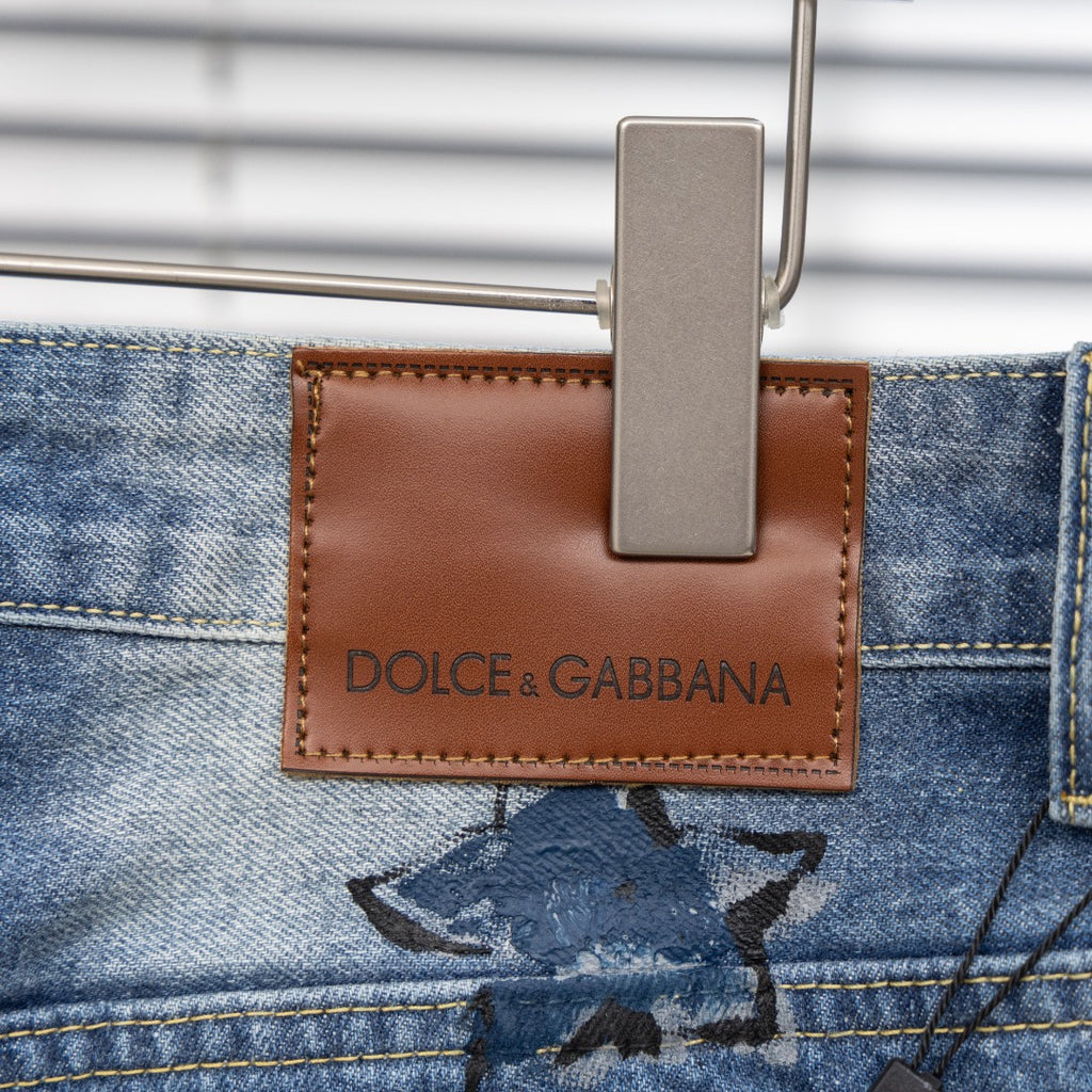 Light-blue jeans with brown leather logo patch reading DOLCE & GABBANA