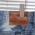 Light-blue jeans with brown leather logo patch reading DOLCE & GABBANA