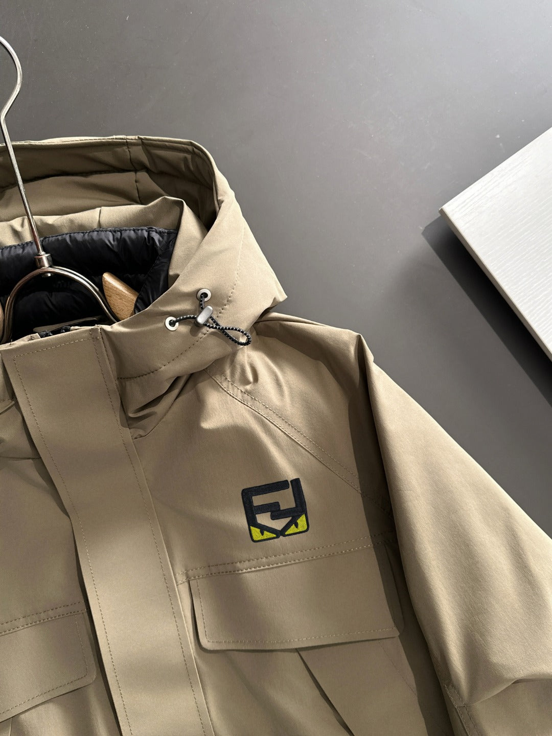Fendi hooded parka jacket in light tan with logo patch, drawcord neck, chest pocket