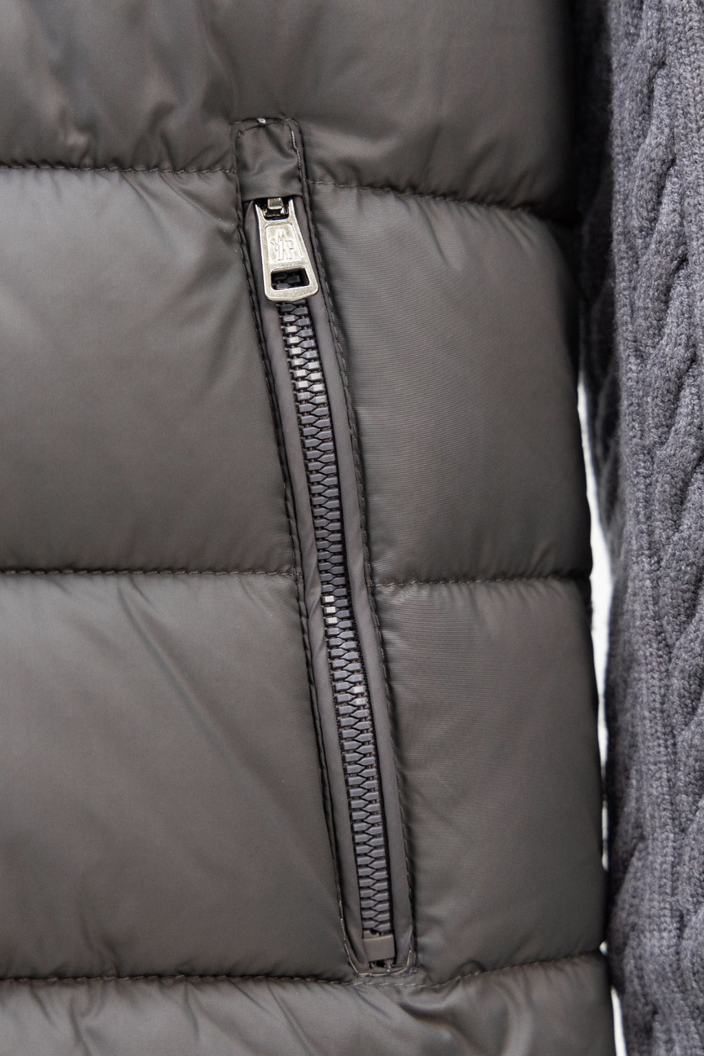 Moncler long puffer jacket front: centered zipper seam on gray quilted fabric