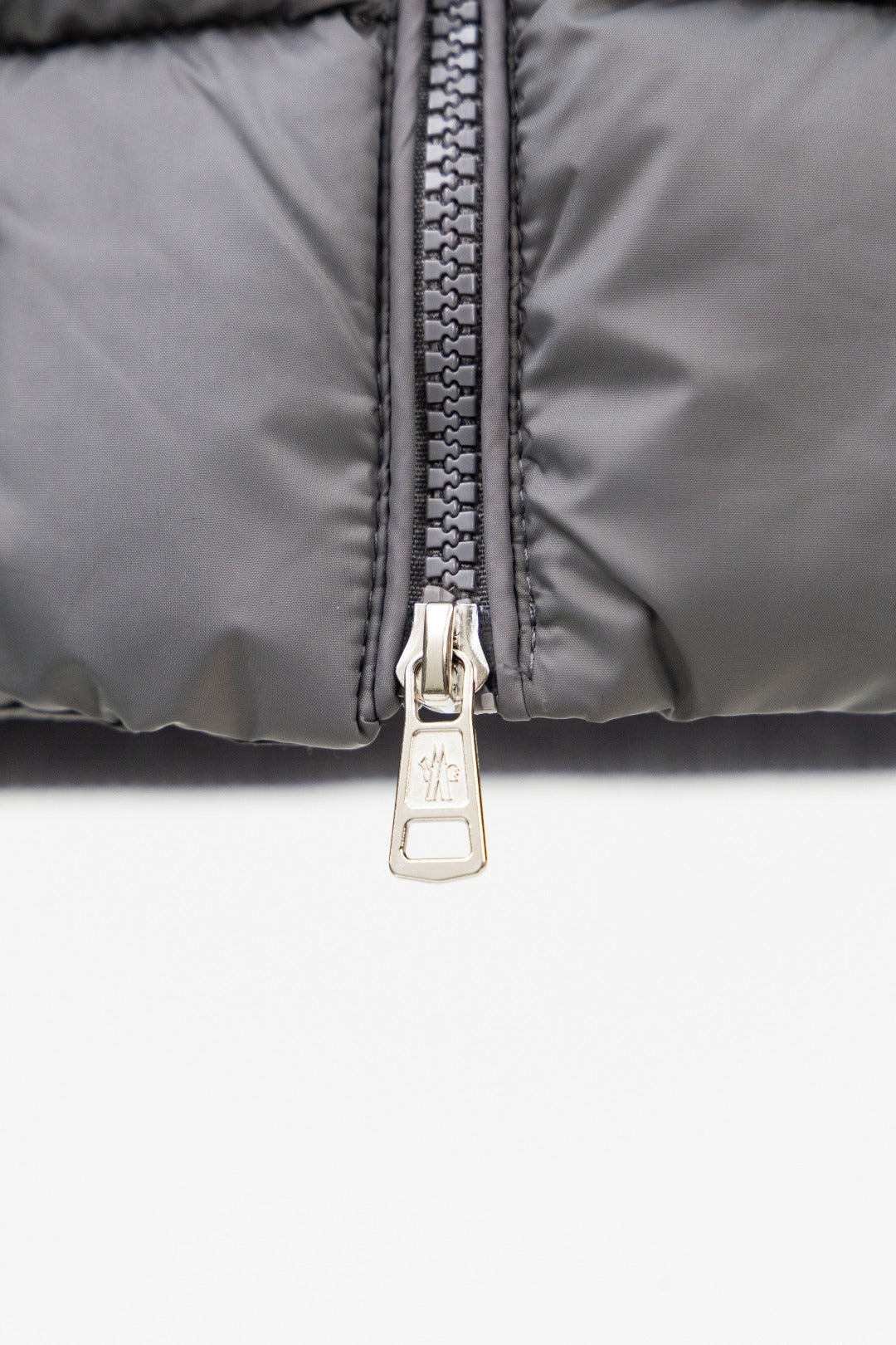 Moncler puffer jacket close-up of dark zipper with metal pull