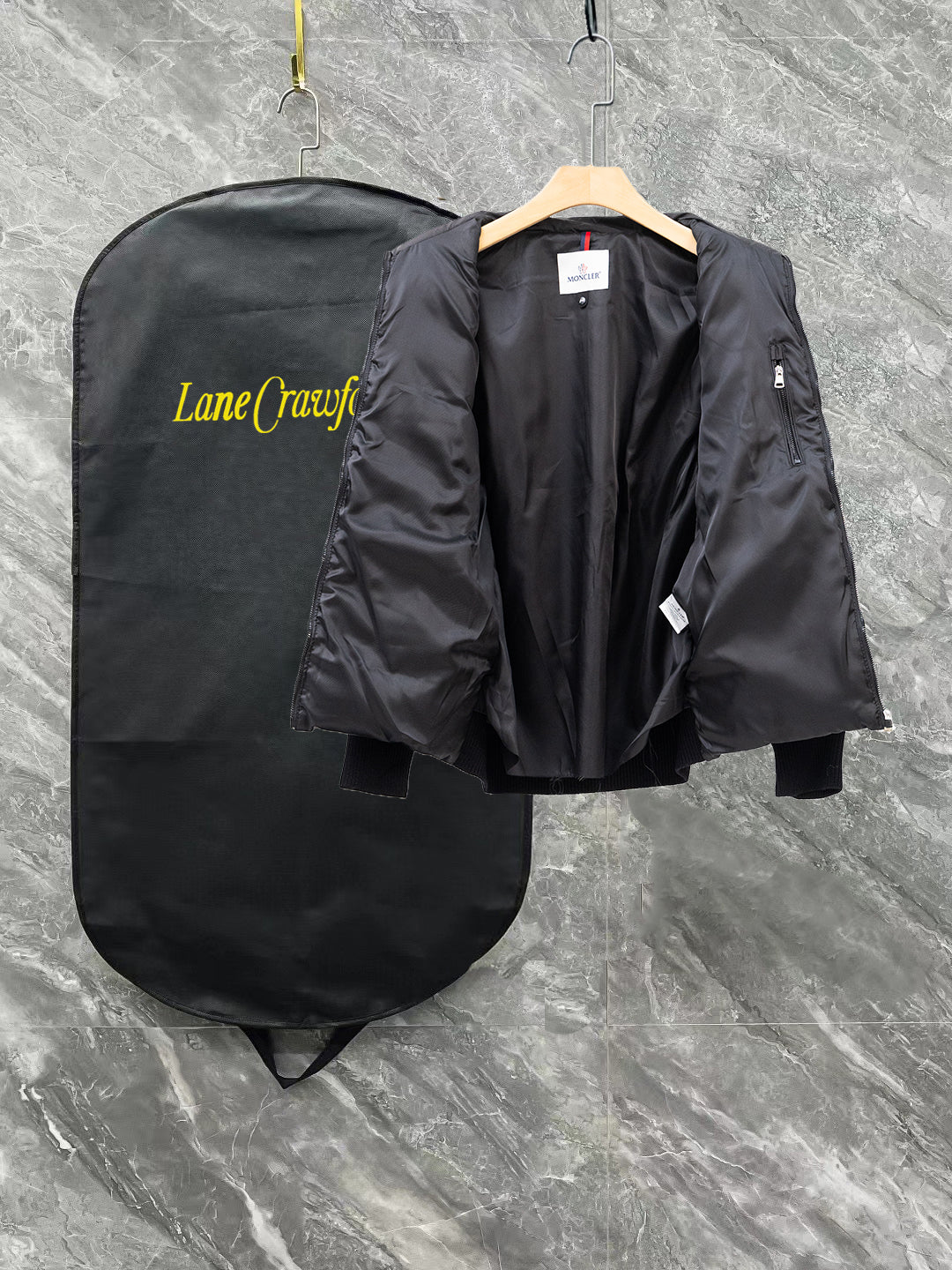 Moncler long black puffer jacket showing back view on hanger