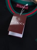 Black Gucci crewneck top with green and red striped collar, hanging tag