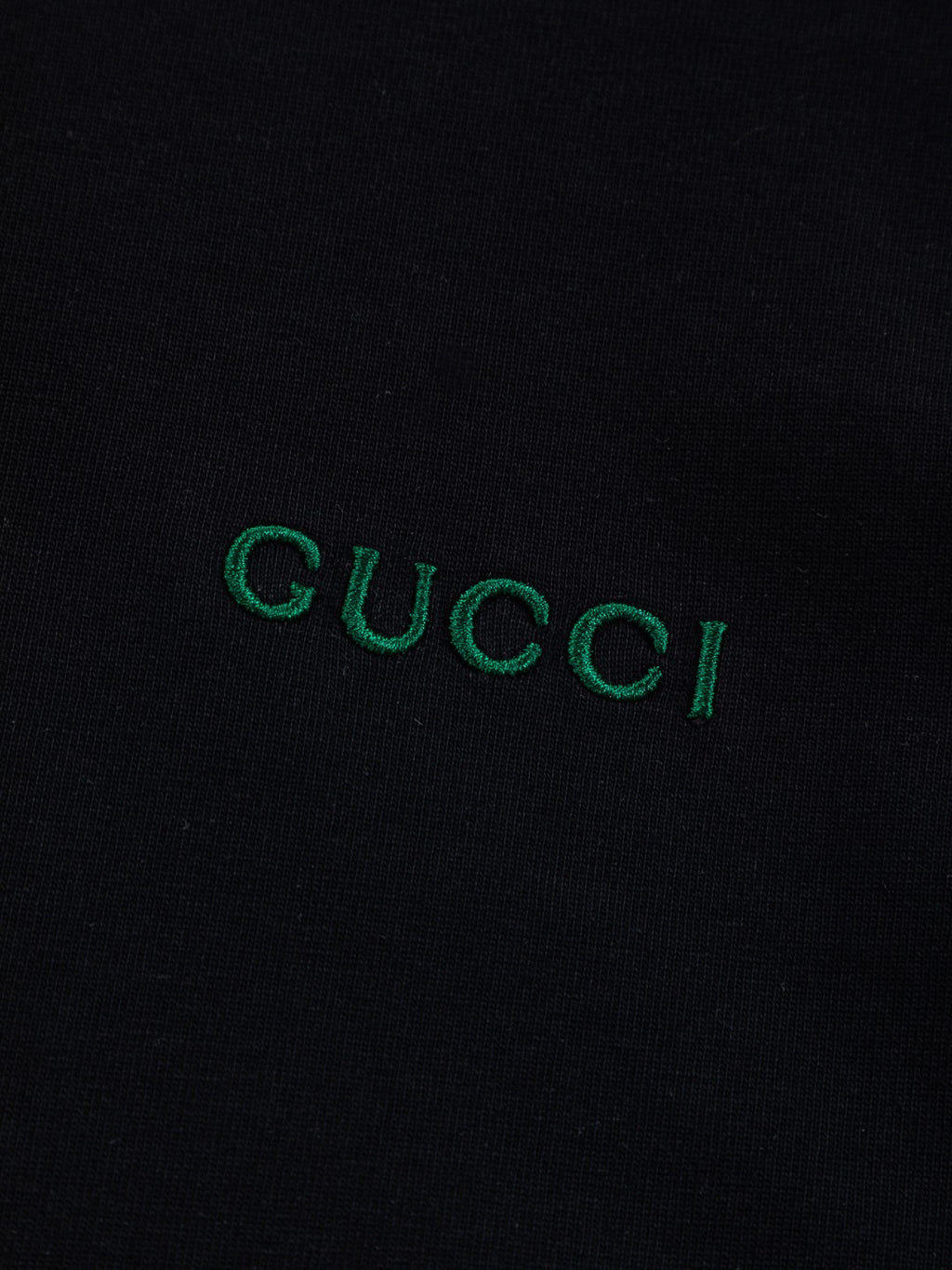 Gucci T-shirt logo on black fabric, green embroidered "GUCCI"