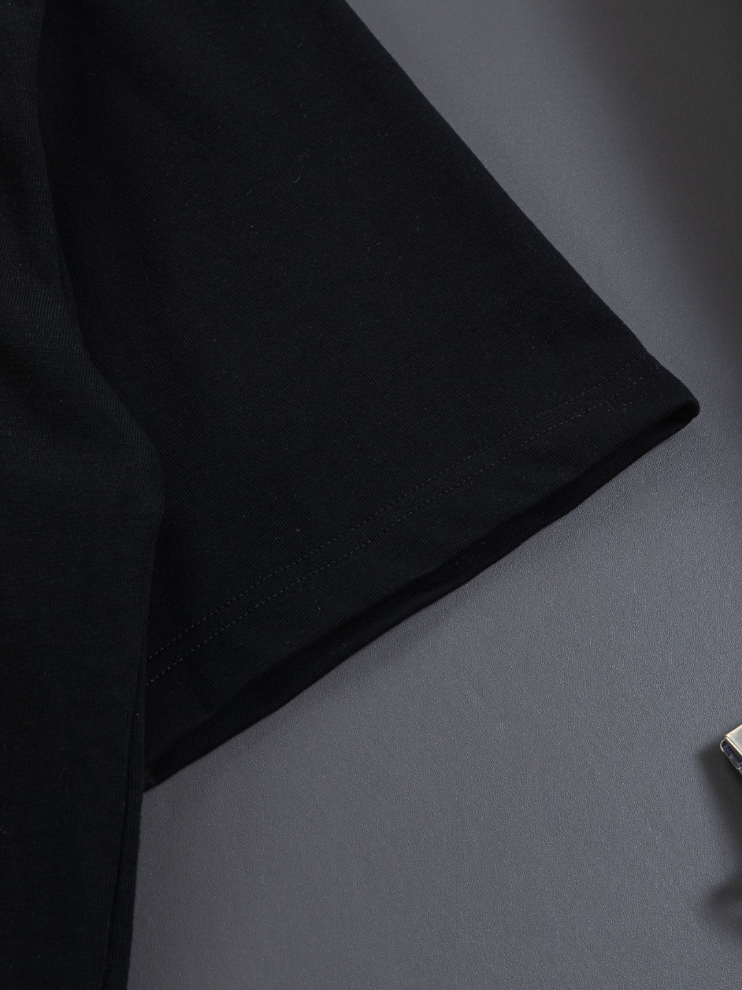 Gucci short-sleeve T-shirt corner detail, black fabric with visible stitching